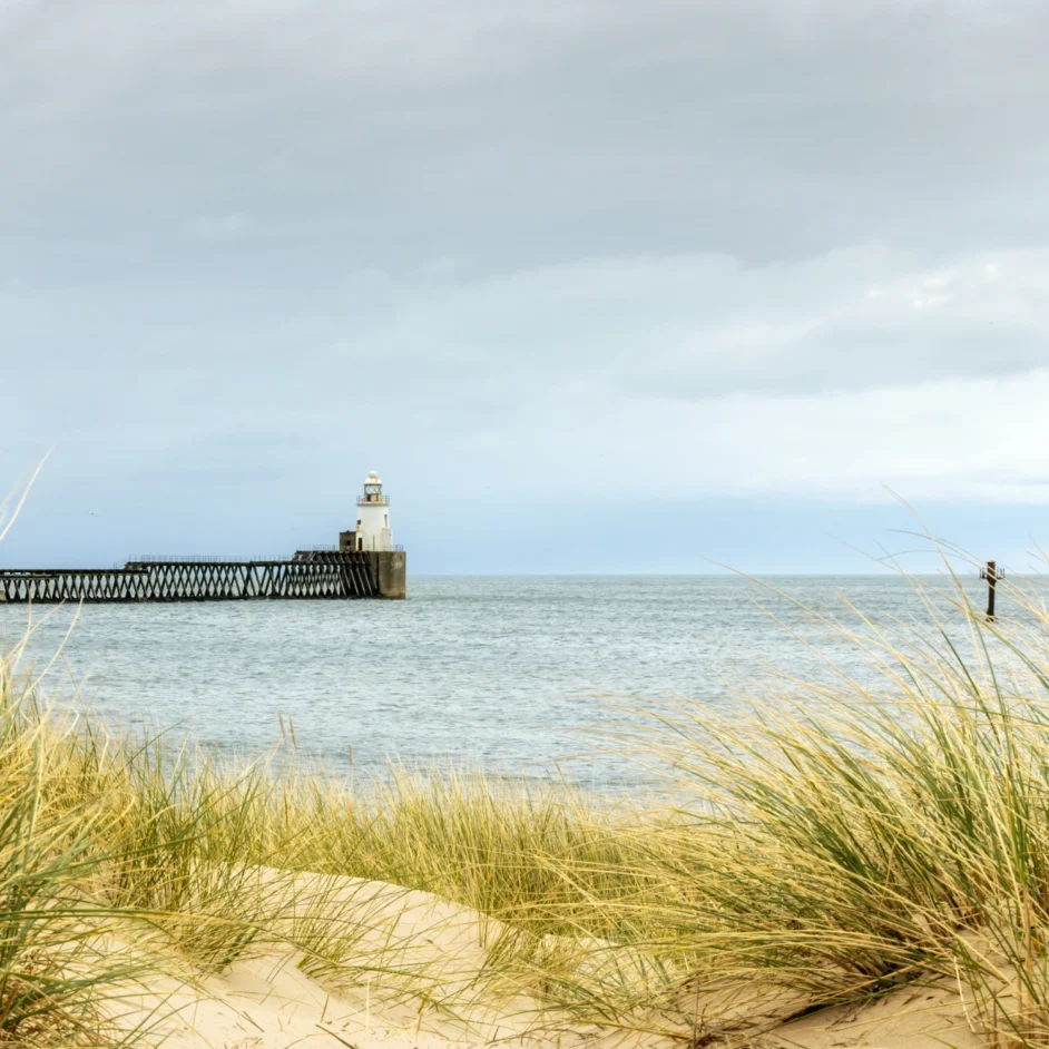 Blyth pier and lighthouse pictured from dunes.